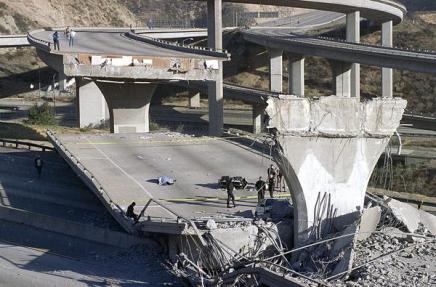 This January 17, 1994 photo shows the covered body of Los Angeles Police Officer Clarence Wayne Dean, 46, near his motorcycle which plunged off the State Highway 14 overpass that collapsed onto Interstate 5, an interchange that is now named in his memory. Dean was reporting to work in the predawn darkness and apparently never saw the collapsed bridge. # AP Photo/Doug Pizac